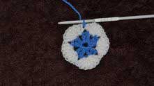 Insert a hook into the white dc and yarn over blue thread.