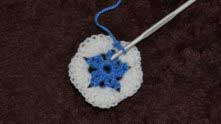 Insert a hook between the two blue dc of 1st row, 1sc, slightly pulling yarn.