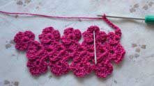 Ch 8, single crochet (sc) in the center of next flower (needle marked).