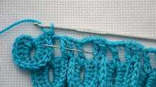 *7 dc in first tr around (needle marked), 1 dc between the scales of the previous row, 7 dc in second tr around.