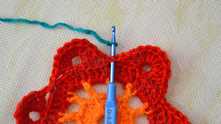 Round 5. Attach the thread of the third color between petals.
