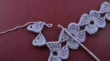 Pull off yarn from the hook. Insert hook in the loop at corner of the flower in the previous row, yarn over and pull loop.