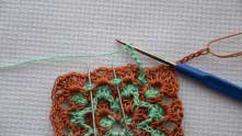 Working green arches around each shell in previous row.